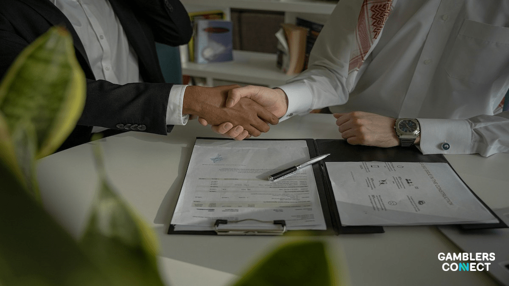 Two businessmen shaking hands to finalize a major transaction, symbolizing the Flutter Entertainment and Boyd Gaming deal over the FanDuel brand.