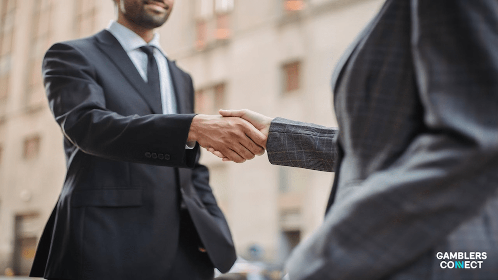 A firm handshake between two business people, illustrating the successful collaboration and agreement between Betby and Satoshi Gaming Group.