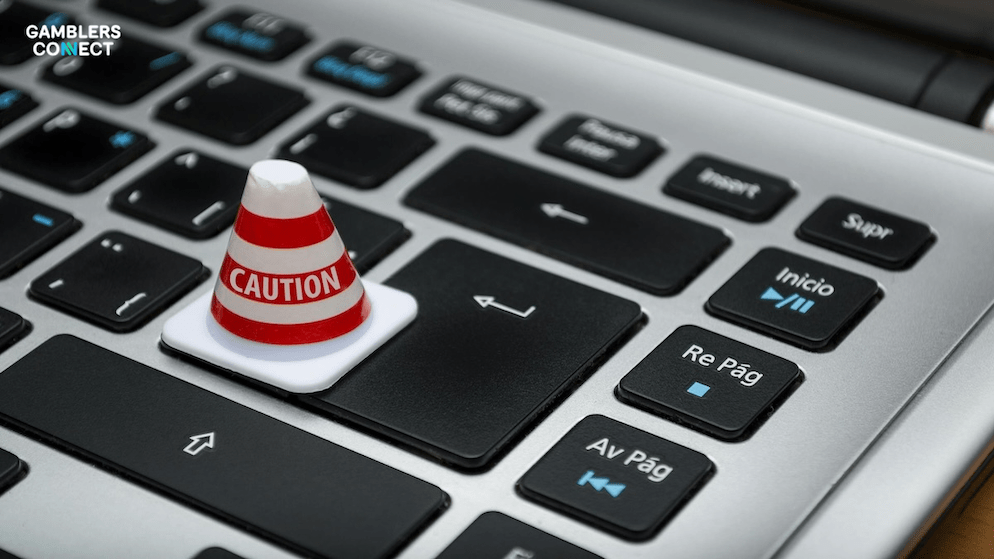 A close-up of a laptop keyboard with a small caution cone on the Enter key, representing the regulatory warning given to TonyBet for breaching Dutch gambling laws.