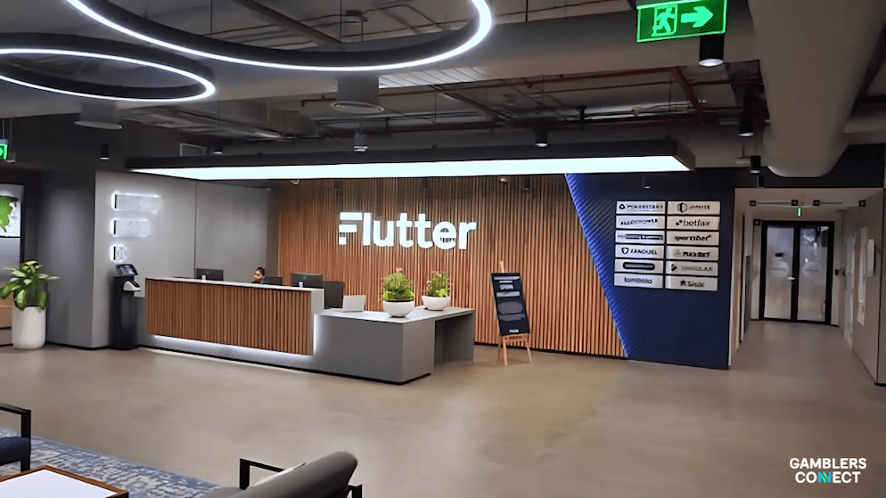 The lobby of a Flutter Entertainment office, displaying the company's portfolio of brands including FanDuel, PokerStars, and Betfair.