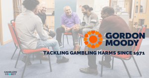 A group of individuals in a support meeting at Gordon Moody House, a residential facility for treating severe gambling-related harm, with the Gordon Moody logo and tagline