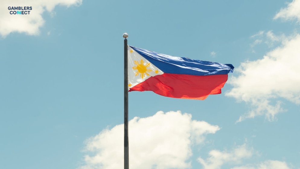 The flag of the Philippines waves against a clear sky, symbolizing the national-level governmental and legislative action being taken to regulate the online gaming industry.