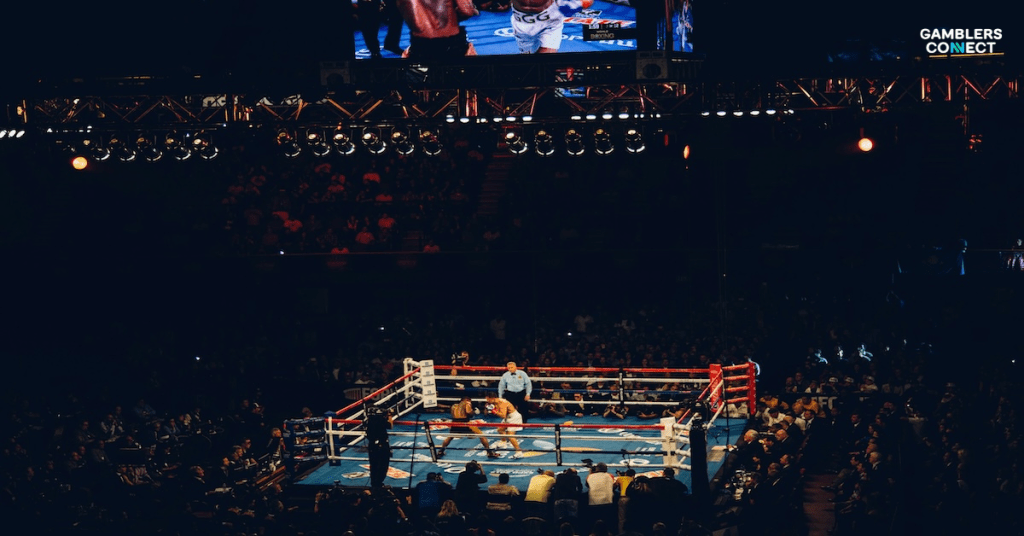 A dynamic shot capturing the action inside a boxing ring during a Queensberry Promotions fight, emphasizing the sport and the context of FDJ United's sponsorship through brands like Unibet.