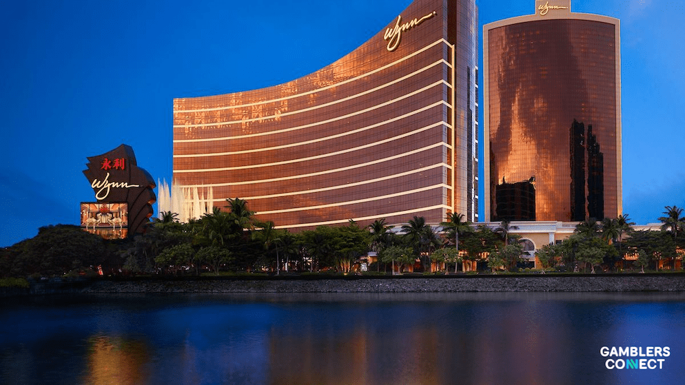 A nighttime view of the Wynn Macau buildings reflecting in the water, representing the company's efforts to manage liquidity and support its operations during the post-pandemic recovery in Macau.