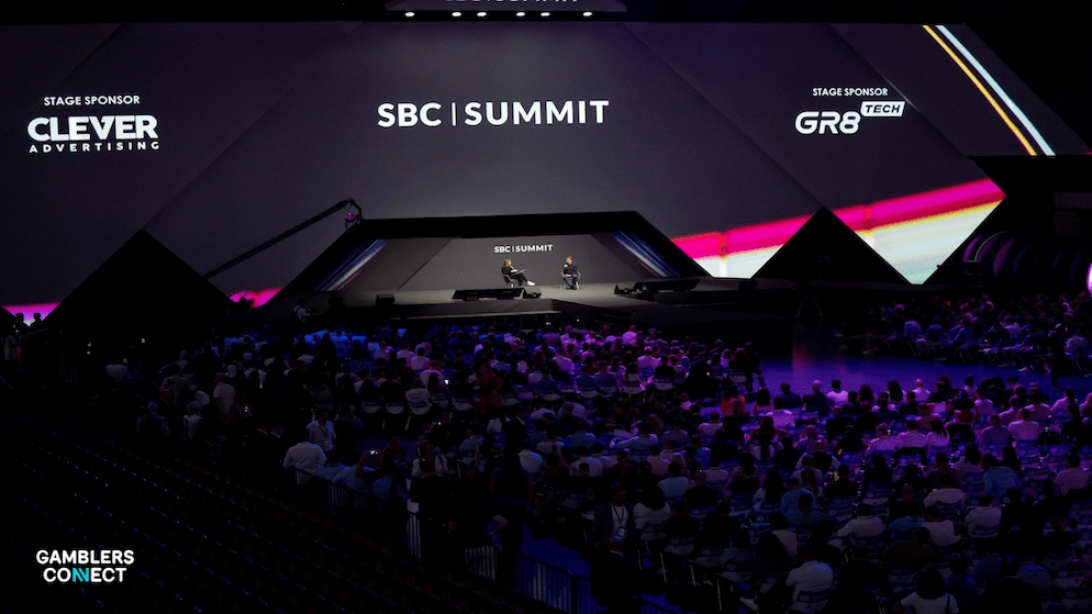 Attendees at the SBC Summit Lisbon conference, watching a presentation on the main stage, illustrating the event's global industry leadership focus.