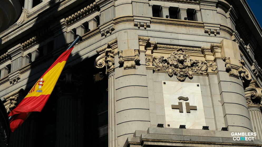 The Spanish flag and a government building facade, representing the DGOJ's oversight of Spain's gaming market and its significant Q2 2025 GGR growth.
