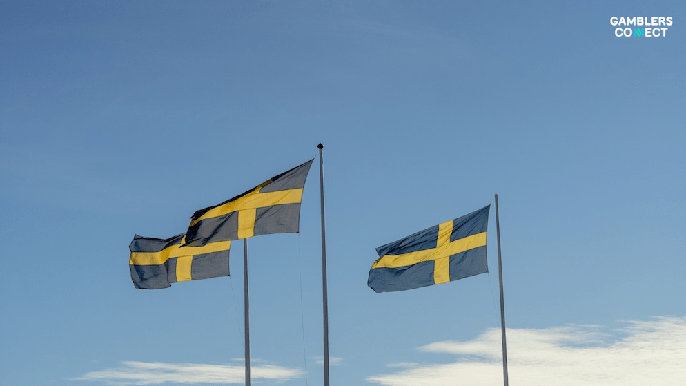 Multiple Swedish flags flying against a bright sky, representing Sweden's regulatory environment as Spelinspektionen intensifies efforts to combat unlicensed offshore online casinos targeting Swedish players.