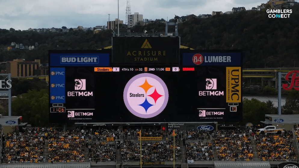 The scoreboard at a packed Acrisure Stadium, home of the Pittsburgh Steelers, featuring prominent BetMGM branding, showcasing the operator's role as an Official Sports Betting Partner.