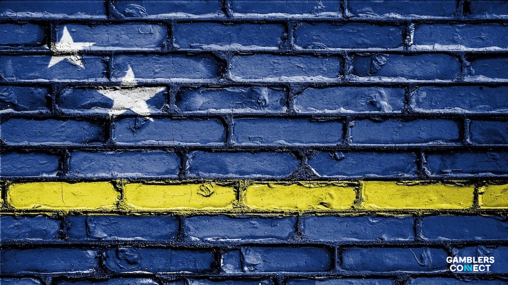 The flag of Curaçao painted on a weathered brick wall, symbolizing the foundational regulatory crisis facing the island's gaming authority after its entire board resigned.