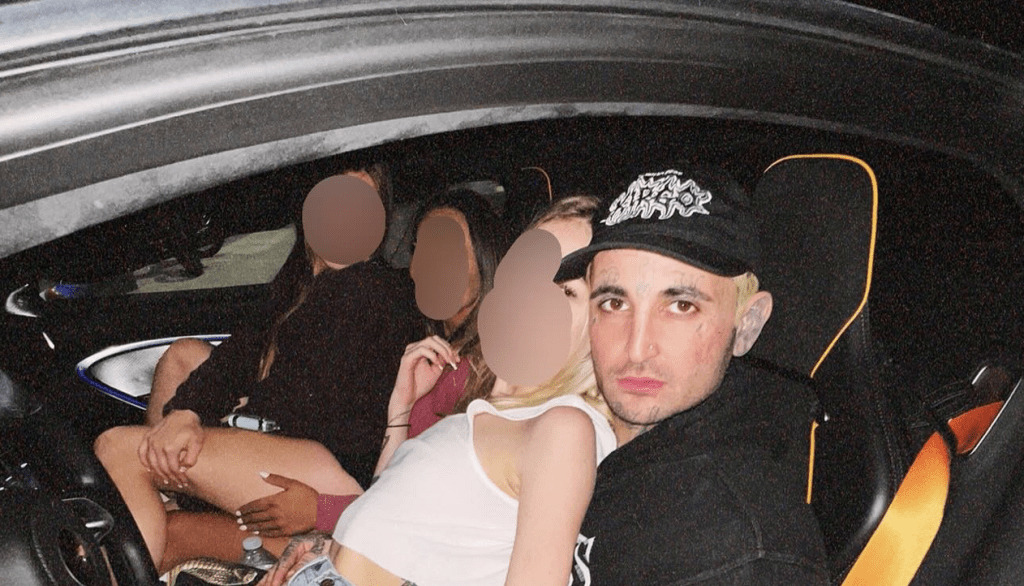Mikki Mase pictured in the driver's seat of his luxury McLaren sports car at night, showcasing the extravagant lifestyle that is a core component of his public persona and a reflection of his claimed net worth.