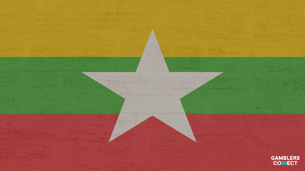 A distressed graphic of the Myanmar flag, representing the nation’s role in regional efforts to combat cybercrime and illegal gambling syndicates operating near border regions like Kayin State.
