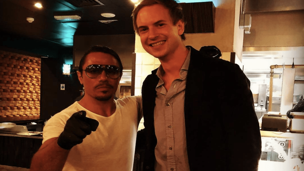 Professional poker player Isildur1 net worth smiling while standing next to celebrity chef Salt Bae in a restaurant kitchen, providing a glimpse into his life outside of poker.