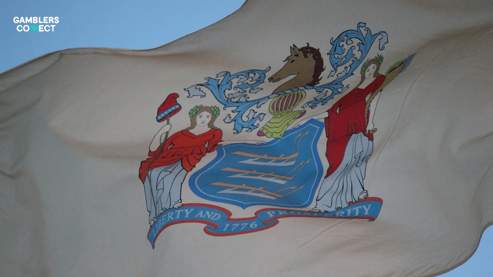 A detailed shot of the New Jersey state flag, highlighting its "Liberty and Prosperity" motto in the context of record iGaming tax receipts. New Jersey October Revenue