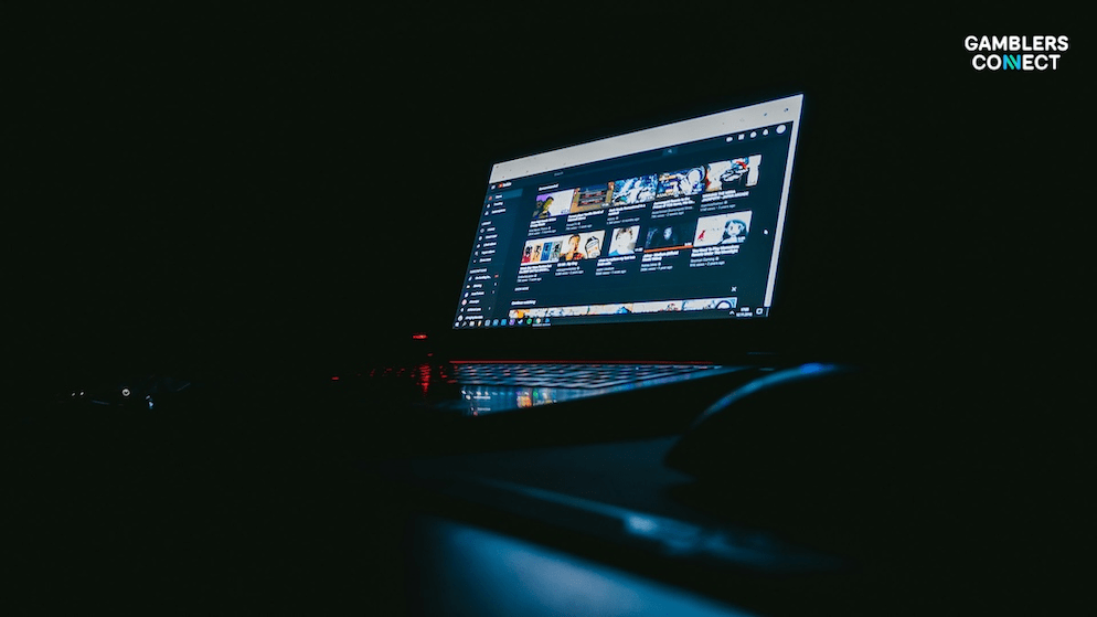 A laptop showing the YouTube video interface in a dark setting, representing the platform's expanded controls on gambling, skin betting, and realistic video game violence.
