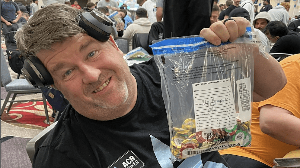 Chris Moneymaker proudly holding a plastic bag full of poker chips, smiling at a live tournament, symbolizing a successful day's play.