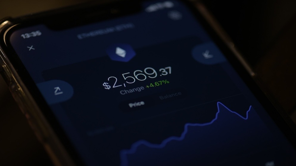 A close-up of a smartphone screen displaying an Ethereum (ETH) price chart and wallet interface, illustrating the end-user benefits of technical bundling solutions like Account Abstraction.