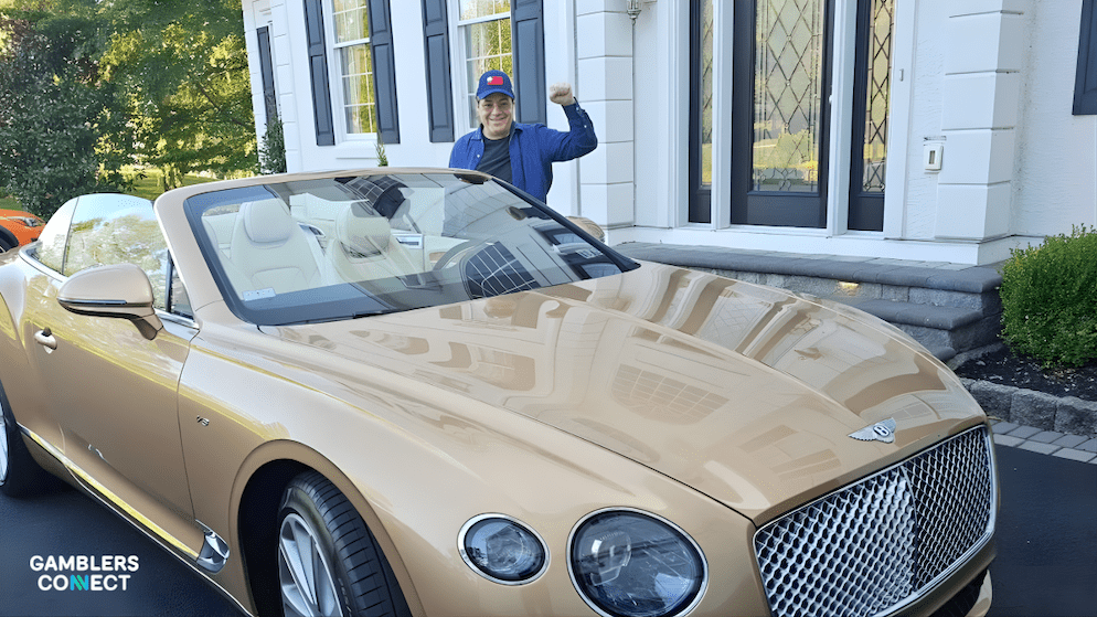 Jamie Gold standing next to a gold/tan Bentley convertible, symbolizing the luxury lifestyle afforded by his poker winnings.