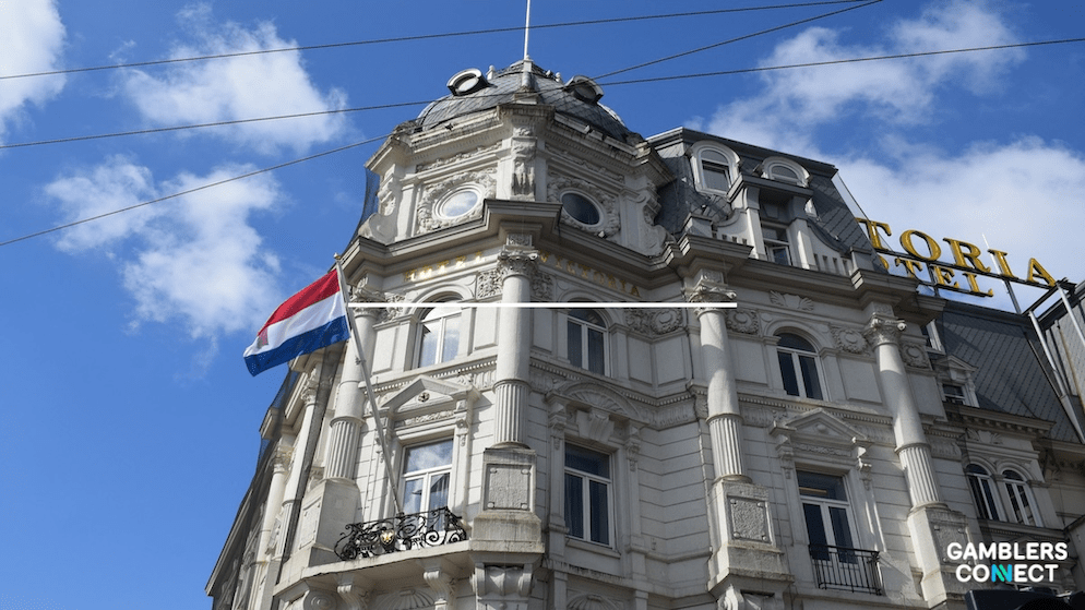 A waving Dutch flag on a historic building, symbolizing the strict regulatory environment for iGaming in the Netherlands.