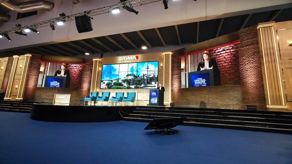 Wide shot of the impressive SiGMA Central Europe stage in Rome, featuring large screens displaying Roberta Metsola speaking.