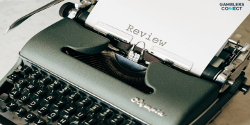 A close-up of a vintage typewriter with a sheet of paper that has the word "Review" typed on it in a classic font.