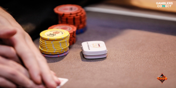A close-up view of a poker player's hands holding cards next to stacks of yellow and orange chips at the PartyPoker Tour London table, featuring the PLO Masters button.