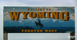 A "Welcome to Wyoming: Forever West" road sign against a mountain landscape, symbolizing the state's entry into the National Voluntary Self-Exclusion Program.