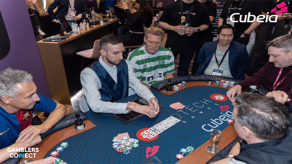 Swedish football legend Henrik Larsson wearing a Celtic FC jersey playing poker alongside Johan Mjällby at the Cubeia and QTech Games stand during the ICE Barcelona expo.