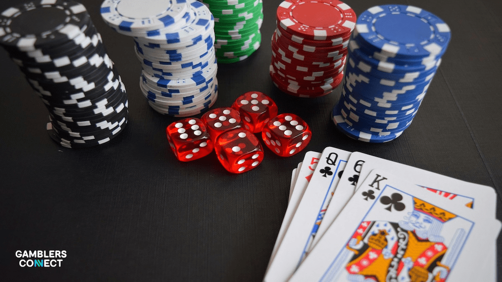 A close-up of casino gaming equipment including chips and dice on a dark table, representing the higher betting limits and table game variety found on platforms licensed outside the Netherlands.