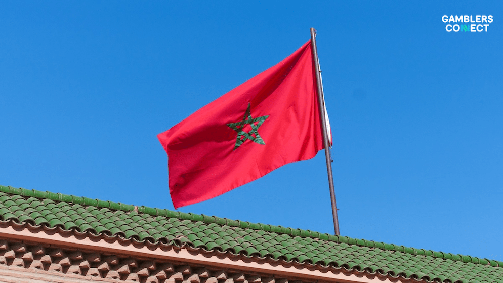 Low-angle view of the Moroccan flag, symbolizing the state-owned operator MDJS's campaign to enforce digital borders against unregulated betting operators.