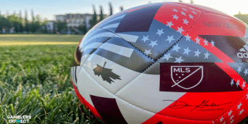 A close-up of an official Major League Soccer (MLS) ball resting on a green grass field, symbolizing the league's new multi-year agreement with prediction market operator Polymarket.