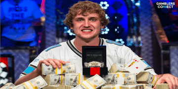 Ryan Riess smiling and posing with the 2013 World Series of Poker Main Event bracelet and piles of cash, wearing his signature Detroit Lions jersey.
