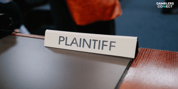 A close-up of a desk sign reading "PLAINTIFF" in a courtroom setting, symbolizing the SEC's lawsuit against Lottery.com executives for inflating revenue.