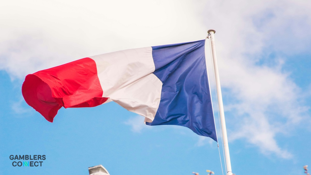 A low-angle shot of France's tricolor flag, symbolizing the national regulatory framework for prediction markets.
