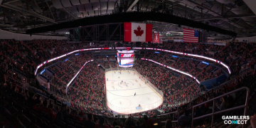 Action shot of a competitive slide on ice, symbolizing the "never-say-die" intensity of NHL playoff overtime periods.