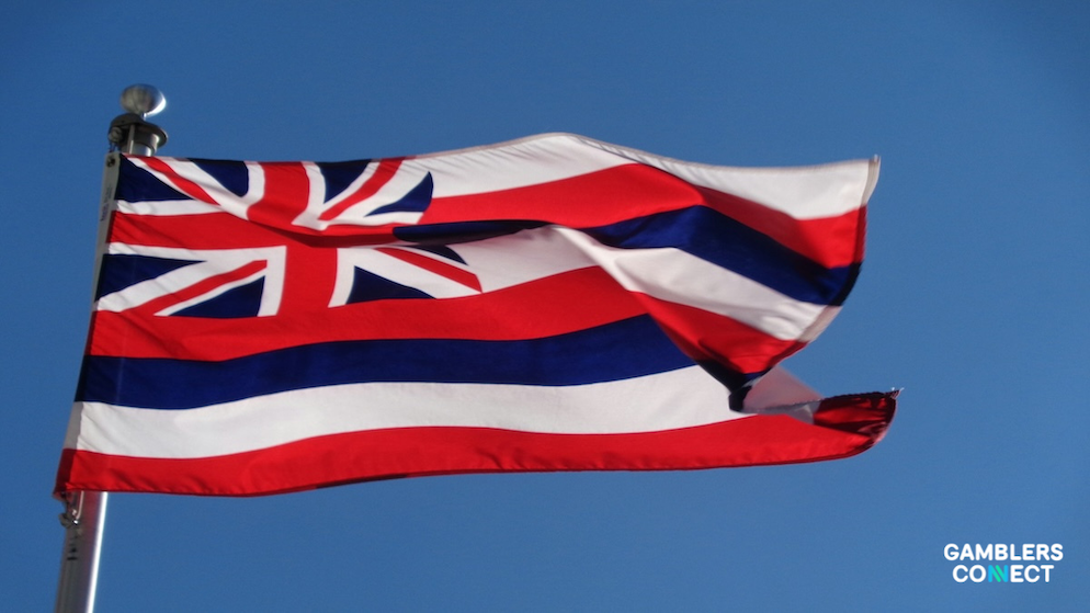 Close-up of a wooden gavel and a smartphone displaying a sports betting app to represent regulatory oversight.