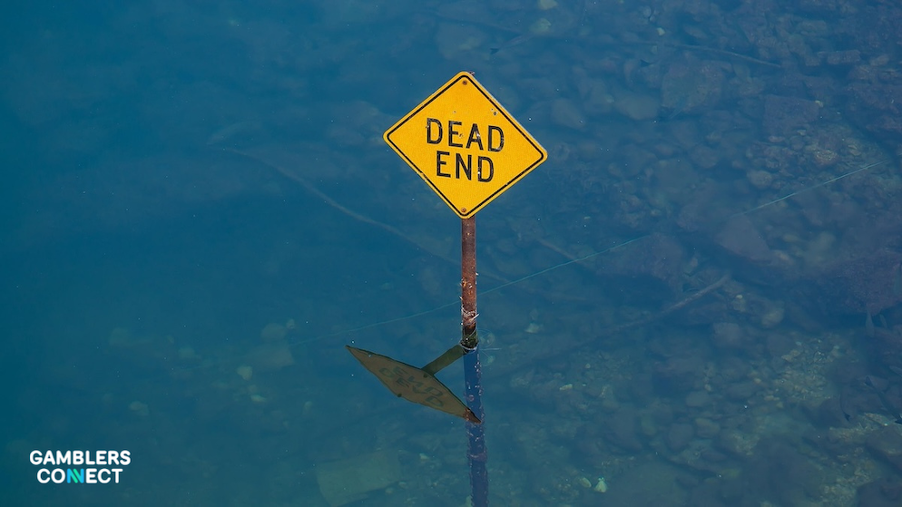A "Dead End" sign submerged in water, symbolizing the looming shutdown of the sweepstakes casino industry in major U.S. markets.
