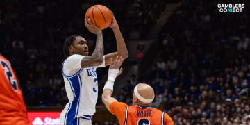 Duke Blue Devils forward Cameron Boozer shooting a jump shot over an NC State defender at the Lenovo Center.