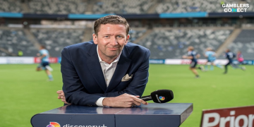 Sports broadcaster Jonas Dahlquist leaning on a broadcast desk with a microphone in a stadium setting, representing his new role at DBET.