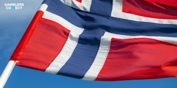 The national flag of Norway waving against a clear blue sky, representing the jurisdiction of Lotteritilsynet.