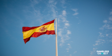 The national flag of Spain waving against a clear blue sky, representing the jurisdiction of the National Police and Europol.