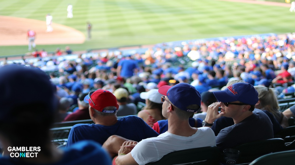 A crowd of sports fans in a stadium wearing team colors, representing the millions of online wagering accounts in Massachusetts.