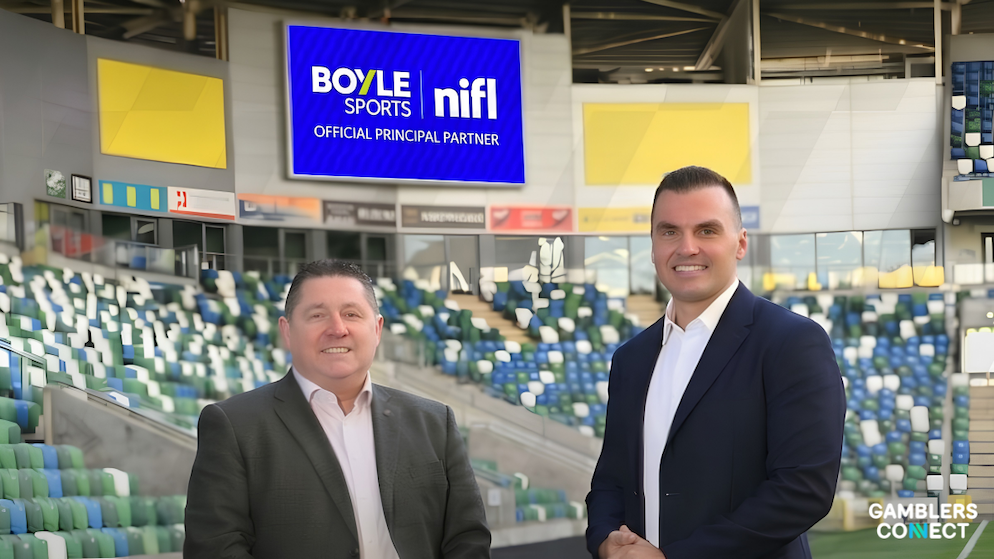Commercial partnership announcement featuring corporate executives standing inside a football stadium beneath a digital screen displaying the BoyleSports and NIFL Official Principal Partner branding with GamblersConnect logo.