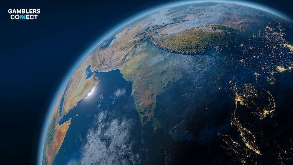 A high-definition satellite view of the planet Earth from outer space, showing the Indian subcontinent, Southeast Asia, and the Middle East illuminated by localized city night lights under a deep blue atmosphere.