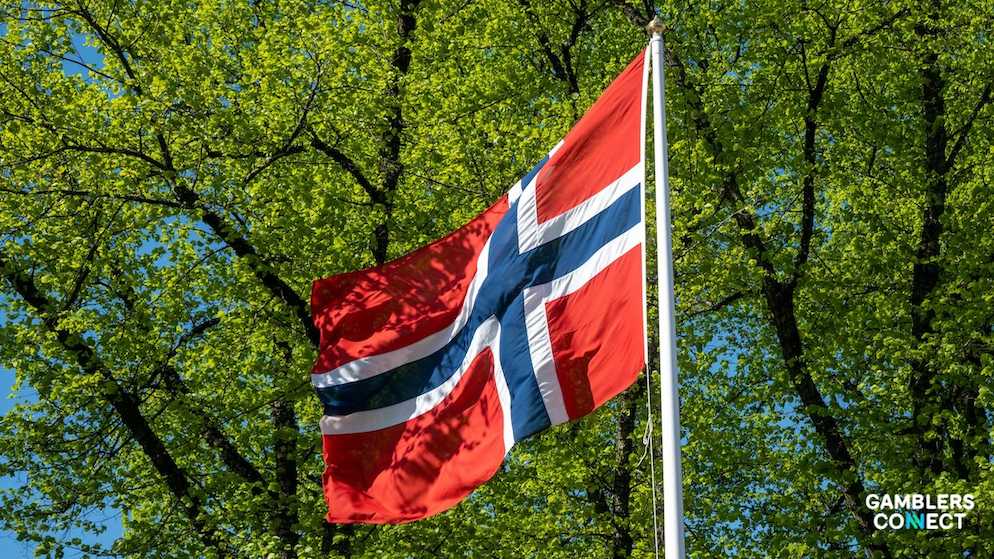 Close-up of the Norwegian flag, symbolizing the sovereign state monopoly market structure and strict ISP domain blocking protocols.