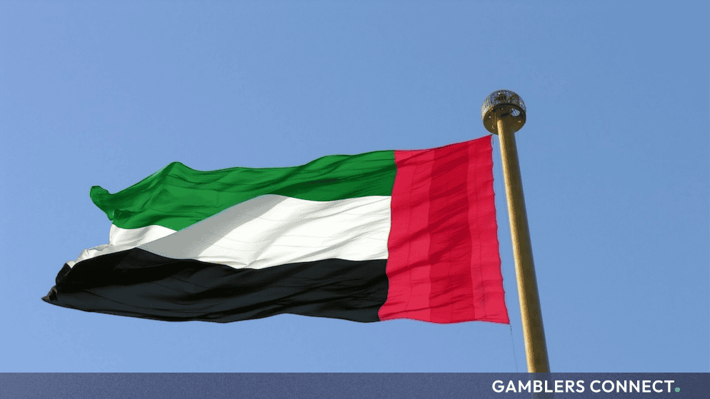 A low-angle shot of the UAE flag flying on a bright day, representing the regional regulatory shifts overseen by the GCGRA.