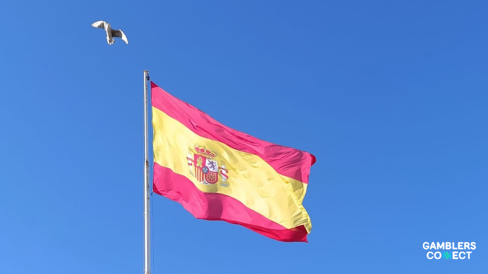 A close up view of the Spanish flag rippling in the wind against a deep blue sky backdrop canvas.