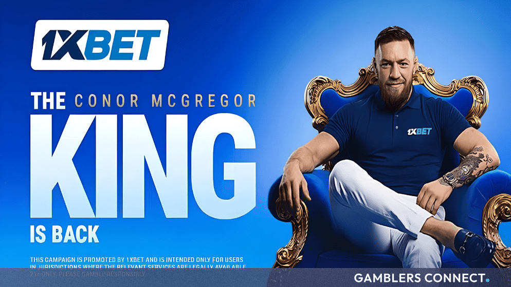 1xBet Secures Long-Term International Partnership with Conor McGregor 1 Conor McGregor wearing a dark blue 1xBet polo shirt and white trousers, sitting confidently in a large blue and ornate gold throne against a bright blue background featuring the 1xBet logo and the text 'THE CONOR MCGREGOR KING IS BACK'.