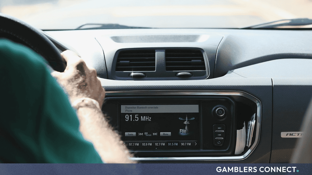 Interior view of a vehicle dashboard displaying an active car radio interface reflecting updated ACMA media legislation and content standards.
