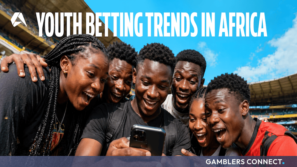 Parsing the Data: Altenar's Report Shows That Youth Betting Trends Are Reshaping African Sportsbooks 1 Young African sports fans cheering while interacting with live mobile data on a cell phone inside a large open-air football stadium.