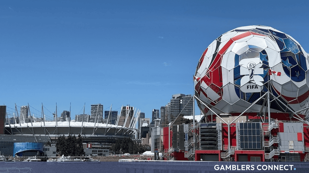 Prediction Markets Surge During 2026 World Cup as Traditional Sportsbook Growth Fades Mid-Tournament 1 Exterior view of a modern sports stadium in Vancouver with a giant soccer ball structure decorated with FIFA World Cup branding and international flags in the foreground under a clear blue sky.